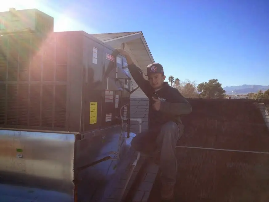 HVAC technician performing Heat Pump Repair on a rooftop unit in Warr Acres
